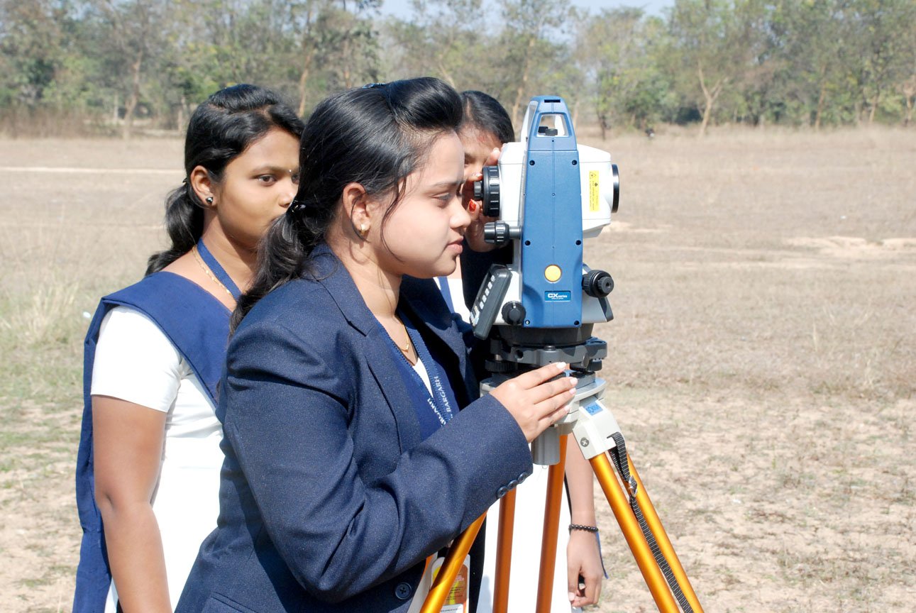 two Civil engineering students are doing practical in college ground